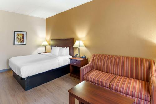 a hotel room with a bed and a couch at Best Western PLUS Governor's Inn Richmond in Midlothian
