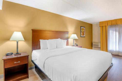 a bedroom with a large white bed and two lamps at Best Western PLUS Governor's Inn Richmond in Midlothian