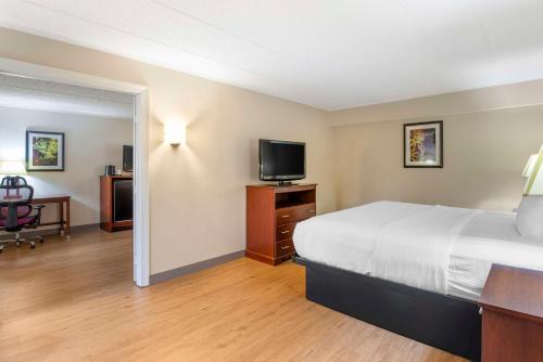 a hotel room with a bed and a flat screen tv at Best Western PLUS Governor's Inn Richmond in Midlothian