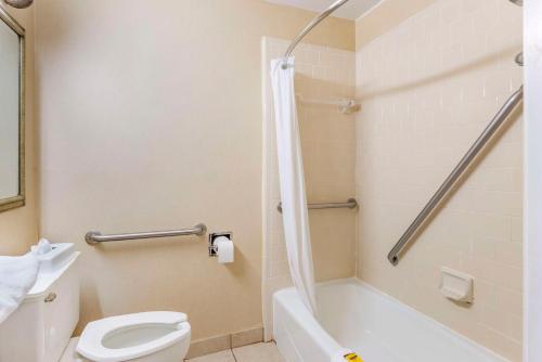 a bathroom with a white toilet and a shower at Best Western PLUS Governor's Inn Richmond in Midlothian