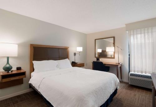 a hotel room with a large bed and a mirror at Hampton Inn Columbia-I-26 Airport in Columbia