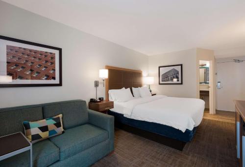a hotel room with a bed and a couch at Hampton Inn Columbia-I-26 Airport in Columbia