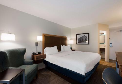 a hotel room with a bed and a chair at Hampton Inn Columbia-I-26 Airport in Columbia