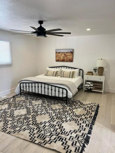 a bedroom with a bed with a ceiling fan and a rug at Sierra del feugo in Ivins