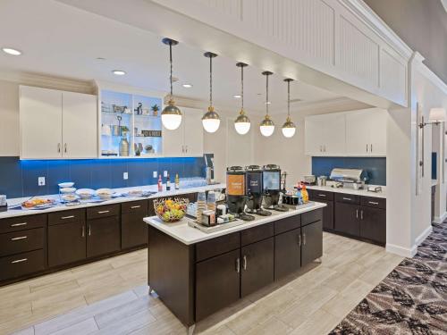 a large kitchen with brown cabinets and blue walls at Homewood Suites by Hilton Joplin in Joplin