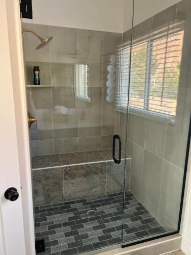 a shower with a glass door in a bathroom at Sierra del feugo in Ivins