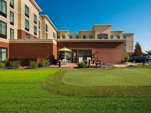 a building with a green yard in front of a building at Homewood Suites by Hilton Joplin in Joplin