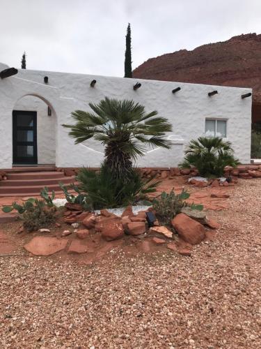 a white building with a palm tree in front of it at Sierra del feugo in Ivins