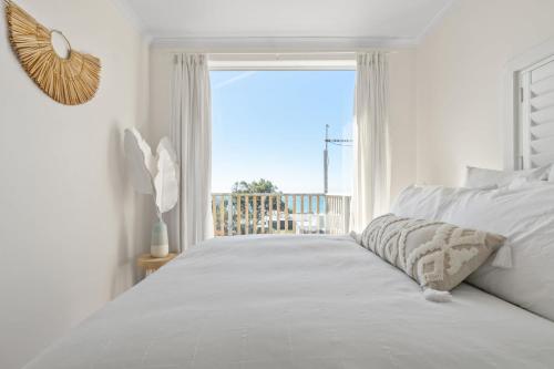 een slaapkamer met een bed en uitzicht op de oceaan bij Shore to Adore: Ocean Views & WiFi in Lulworth