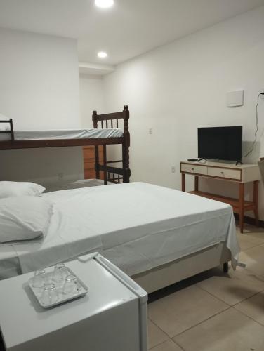 ein Krankenhauszimmer mit 2 Betten und einem Schreibtisch in der Unterkunft Flat para 4 pessoas bem pertinho da praia de Geriba in Búzios
