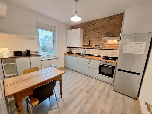 cocina con mesa de madera y nevera en Apartment Mörlenzauber, en Ober-Mörlen