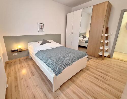 1 dormitorio con 1 cama grande y espejo en Apartment Mörlenzauber, en Ober-Mörlen