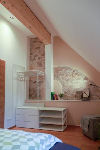 a bedroom with a white bed and a brick wall at Neu - Wenkheimer Hof Scheunen-Loft in Iphofen