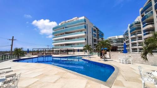 una piscina frente a un gran edificio en Praia Grande Le Bon Vivant 306, en Arraial do Cabo