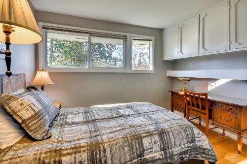 1 dormitorio con 1 cama, escritorio y 2 ventanas en Laptop-Friendly Greensboro Home with Fireplace! en Greensboro
