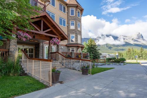 a house with a mountain in the background at Romantic Mountain Escape - Hot Tubs & Private Balcony! managed by Little Sister Getaways in Canmore