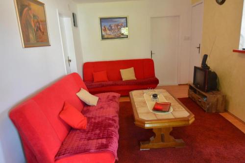 a living room with a red couch and a coffee table at Apartman Armenia in Vrnjci