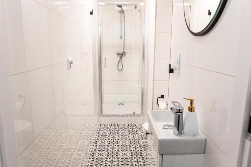 a white bathroom with a shower and a sink at CracWoW K8 No.6 Apartment in Krakow