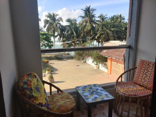 a room with two chairs and a window with a view of the beach at Afiki in Ankwanda
