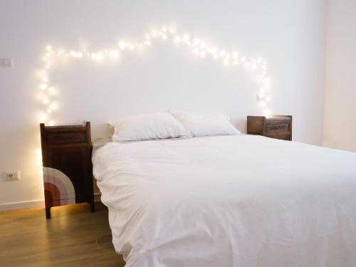 Un dormitorio con una cama blanca con luces. en Anita Bnb Rimini en Rímini