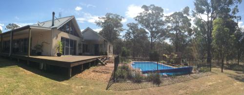 a house with a deck and a swimming pool at Huge house Your Hunter Valley Wine Staycation ! in Pokolbin