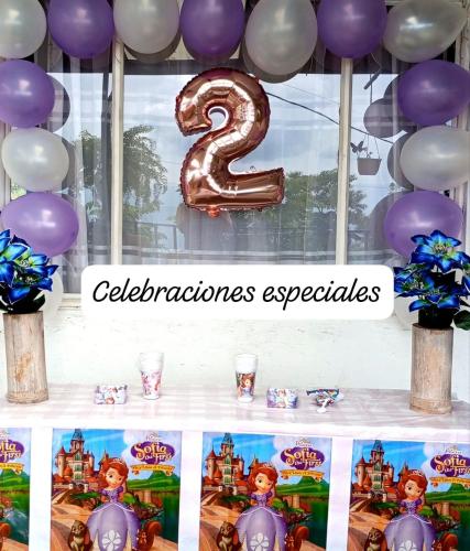 a table with purple and white balloons and a number two at Mirador La Gloria in Misiones