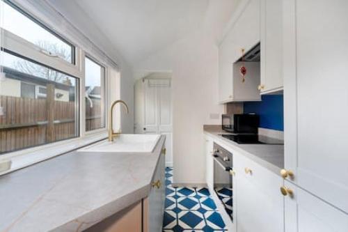 una cucina con lavandino e finestra di Cosy 2-bedroom house in Croydon a Croydon