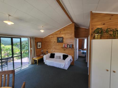ein Schlafzimmer mit einem Bett in einem Zimmer mit Holzwänden in der Unterkunft Off The Beaten Trail Acc & Bike Tours in Murchison