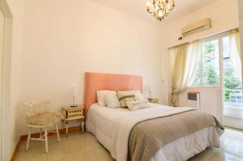 Un dormitorio con una cama y una silla y una ventana. en Dpto. en Recoleta: cálido, próximo y confortable, en Buenos Aires