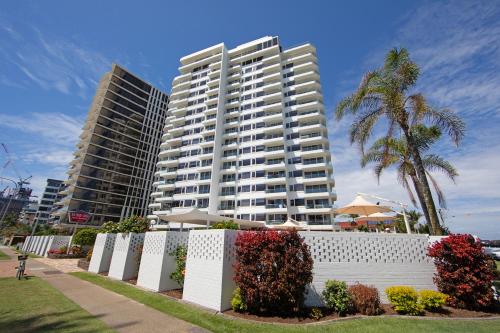 a white fence in front of a tall building at Southern Cross Beachfront Holiday Apartments in Gold Coast