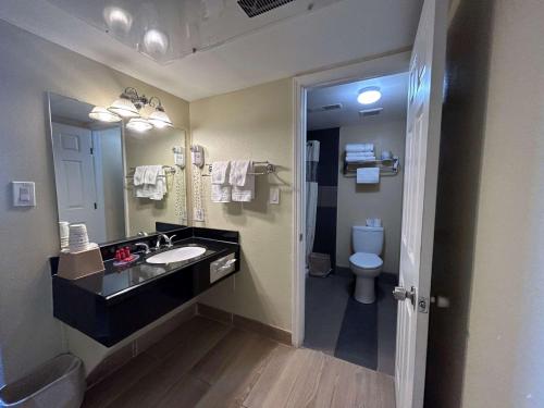 y baño con lavabo y aseo. en SureStay by Best Western Chambers Petrified Forest, en Chambers