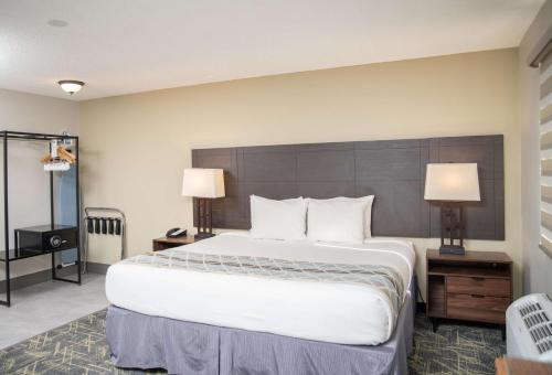 a large bed in a hotel room with two lamps at SureStay Plus by Best Western Montrose in Montrose