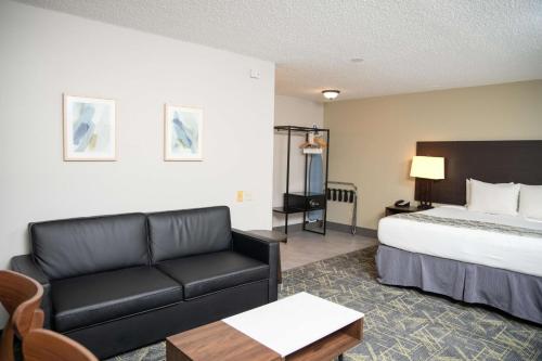 a hotel room with a bed and a couch at SureStay Plus by Best Western Montrose in Montrose