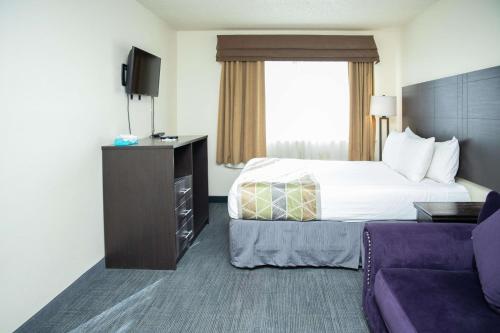 a hotel room with a bed and a couch at SureStay Plus by Best Western Montrose in Montrose
