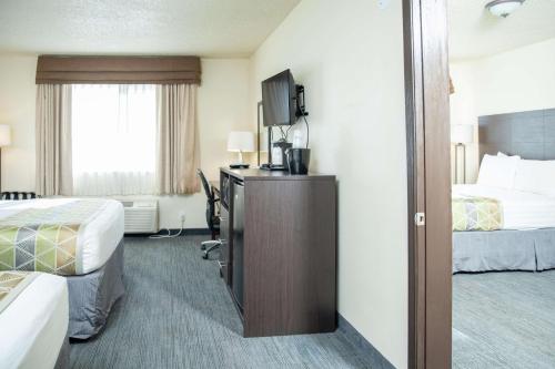 a hotel room with two beds and a television at SureStay Plus by Best Western Montrose in Montrose