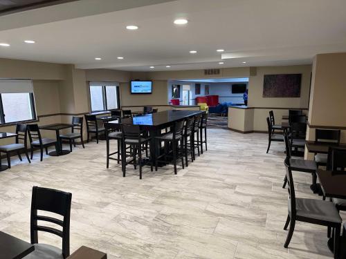 a dining room with tables and chairs and a bar at SureStay Plus by Best Western Mobile I-65 in Mobile