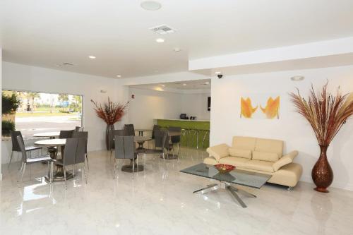 - un salon avec un canapé, une table et des chaises dans l'établissement Orlando International Drive North Hotel, à Orlando