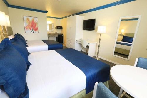 a hotel room with two beds and a table at Orlando International Drive North Hotel in Orlando