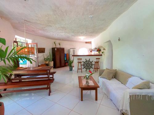 een woonkamer met een bank en een tafel bij Casa ecológica surf e natureza in Camassari