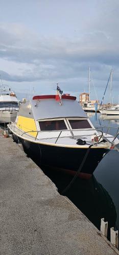 un bateau est amarré à un quai dans l'eau dans l'établissement Appartement sur l'eau tout confort, au Barcarès