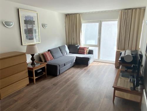 a living room with a couch and a tv at King Bed at London Bridge Apt/Modern And Secure in London