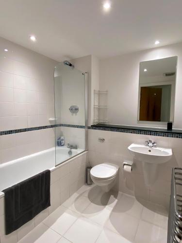 a bathroom with a toilet and a sink and a shower at King Bed at London Bridge Apt/Modern And Secure in London