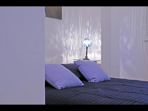 Cama con almohadas moradas y lámpara en la parte superior en Bordeaux charming center, en Burdeos