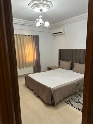 - une chambre avec un lit et un lustre dans l'établissement Coin chaleureux coté plage, à Hammam Sousse