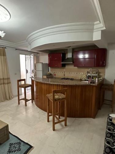 - une cuisine avec des placards en bois et un comptoir dans l'établissement Coin chaleureux coté plage, à Hammam Sousse