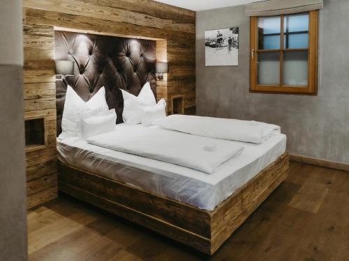 a large bed in a room with a wooden wall at Chalet-Apartment Lavendel am Lift in Kirchberg in Tirol