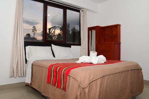 a bedroom with a bed with two towels on it at LA CASA DEL TURISTA in Chachapoyas