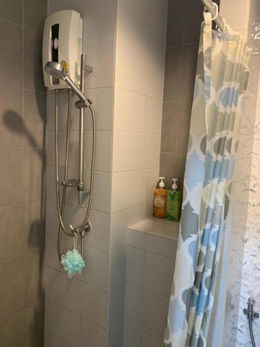 a shower in a bathroom with a shower curtain at The Trust @BTS Chang Erawan. in Ban Bang Yai