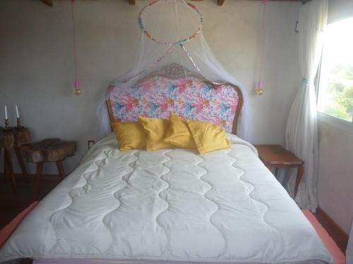 a bed in a bedroom with a headboard and pillows at IDALIA in Barra del Chuy