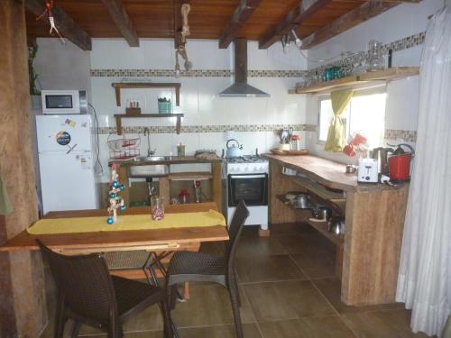 a kitchen with a wooden table and chairs and a refrigerator at IDALIA in Barra del Chuy